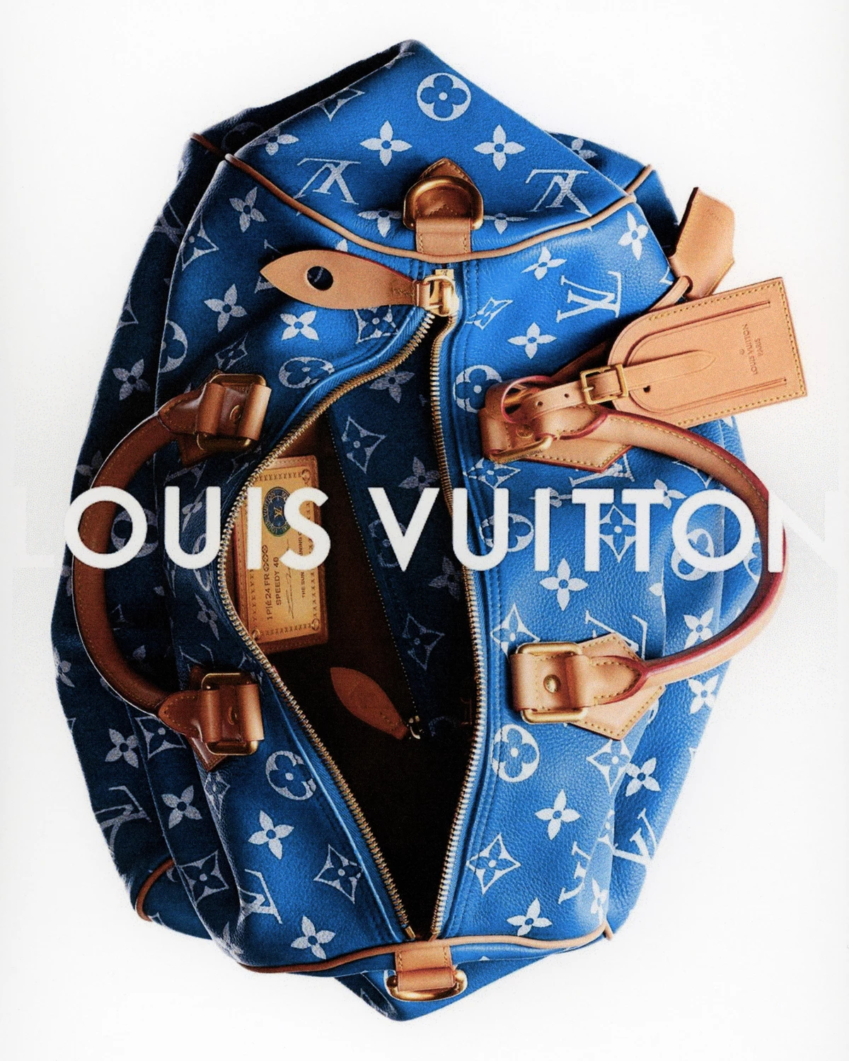 Product photography of an open blue monogram canvas Louis Vuitton Speedy bag with tan leather straps and hardware against a white background, overlaid with white sans-serif typography reading "LOUIS VUITTON".